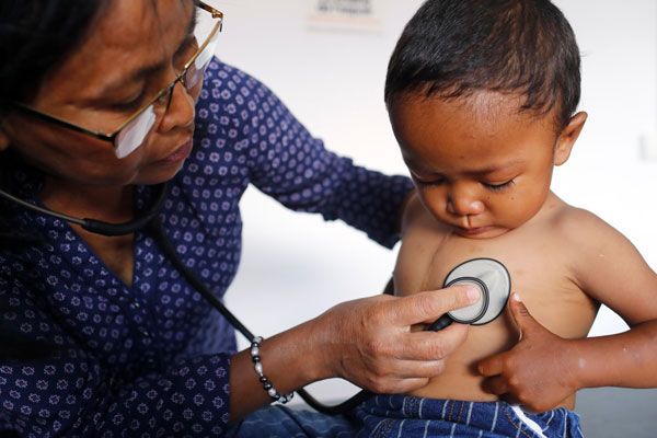 Médecin réalisant un examen médical d'un enfant malgache