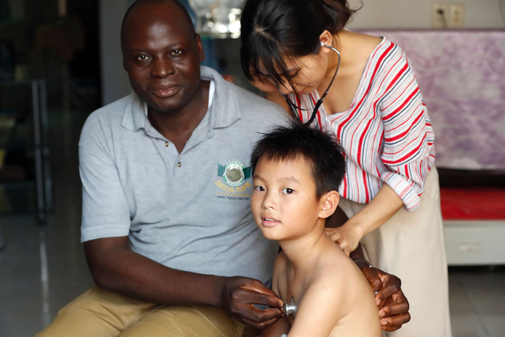 Doctor Adama Sawadogo examines a child at the Saigon Children&apos;s Pavilion in Vietnam